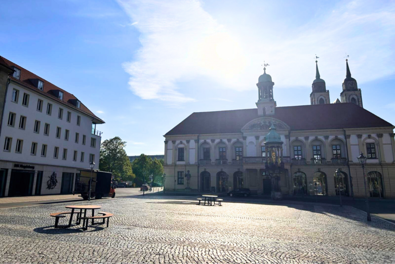 man sieht die IHK Magdeburg und das Rathaus im Sonnenschein.