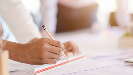 Hand mit Stift füllt Antrag aus